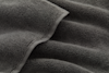 Close-up of a soft, dark gray microfiber towel. The image shows the towel’s textured, looped fibers and slightly folded, plush surface, highlighting its absorbent and cozy appearance.