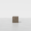 A minimalist wooden nightstand with two drawers, shown from the side against a plain white background.