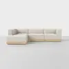 A modern, L-shaped sectional sofa with light beige upholstery and a light wooden base, set against a plain white background on a smooth, light gray floor.