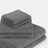 A neatly stacked set of gray towels in various sizes is shown against a white background. The towels appear soft and plush, suggesting they are made of absorbent material like cotton.