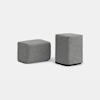 Two gray, rectangular, fabric-covered ottomans placed on a white background; one ottoman is positioned upright, while the other is lying on its side.