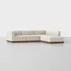 A modern, L-shaped sectional sofa with cream-colored upholstery and a wooden base, set against a plain white background.