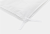 A close-up of a white fabric corner with a neatly tied ribbon, likely the corner tie of a duvet cover, on a plain white background.