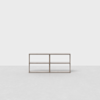 A minimalist wooden console table with an open shelf design and four compartments, placed against a blank white background and sitting on a light gray floor.