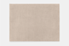 A rectangular beige area rug with a soft, solid color and subtle texture, photographed against a white background.