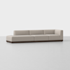 A modern, light beige sectional sofa with clean lines and a low, dark wooden base, placed in a minimalist, empty room with a light grey floor and white background.