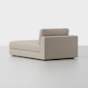 A modern, light beige chaise lounge with clean lines and a low backrest, positioned in a minimalist, light-colored room with a smooth floor and plain white background.