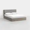 A modern queen-sized bed with a light wood frame and a gray upholstered headboard, dressed in white bedding and pillows, placed in a minimal, bright room with a plain white background.