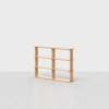 A light wood, three-shelf bookcase with an open back and simple, minimalist design, placed on a light gray floor against a plain white background.
