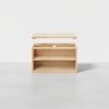 A wooden storage box with an open top lid, revealing two shelves inside, placed on a light gray surface against a plain white background.