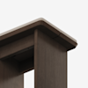 Close-up view of the corner of a dark wooden table or desk with smooth edges and a light-colored top surface, set against a plain white background.