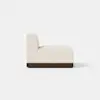 Side view of a modern armless sofa seat with light beige upholstery and a dark wooden base, set against a plain white background.