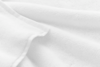 Close-up of soft, white terry cloth fabric with subtle texture and gentle folds. The surface appears fluffy and absorbent, suggesting it may be a towel or bathrobe.