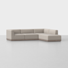 A modern, light beige L-shaped sectional sofa with clean lines and low backrests sits on a smooth, light gray floor against a plain white background.