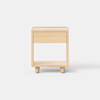 A minimalist wooden nightstand with a single drawer and an open lower shelf, standing on short cylindrical legs against a plain white background.