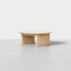 A modern, round, light wood coffee table with a flat top and three wide, flat legs, set against a plain white background.