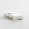 A minimalist single bed with a beige upholstered base, white bedding, and a pillow, set against a plain white background in a modern, empty room.