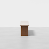 A minimalist rectangular table with a light-colored top and a solid wooden base, photographed against a plain white background.