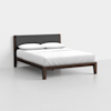 A modern bed with a dark wooden frame, upholstered grey headboard, white mattress, and two white pillows, placed in a minimalist room with a light gray floor and white walls.
