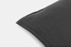 Close-up of a dark gray pillow with a visible seam, positioned on a white background.