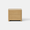 A minimalist wooden nightstand with two drawers, featuring a natural light wood finish and clean, rounded edges, stands against a plain white background.