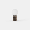 A modern table lamp with a spherical white glass shade and a cylindrical brown marble base, set against a plain white background.