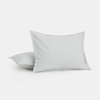 Two plain white pillows are displayed against a white background, with one pillow lying flat and the other propped upright in front of it.