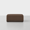 A square brown ottoman with a textured fabric cushion and a dark wooden base, positioned on a light-colored floor against a plain white background.