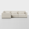 A modern, light beige L-shaped sectional sofa with low backrests and rectangular cushions, set against a plain white background on a smooth, light-colored floor.