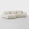 A modern, light beige sectional sofa with three seat cushions, three back cushions, two armrests, and an extended chaise lounge on the left, set against a plain white background.
