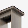 Close-up view of the corner of a modern wooden table or desk with a smooth, light gray finish and a black protective edge on the tabletop, set against a plain white background.