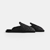 Two black, textured slip-on slippers with an open back and thick sole are displayed side by side against a plain white background.