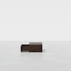 A dark wooden rectangular box with one drawer partially open, placed on a plain light gray surface with a white background.