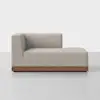 A modern, light beige sectional sofa with a wooden base is shown in profile against a plain white background. The sofa has clean lines, a low back, and left-side armrest.
