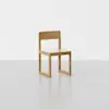 A simple wooden chair with a flat seat, straight backrest, and minimalist square frame, placed on a light gray floor against a plain white background.