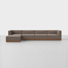 A modern, sectional brown sofa with a left-side chaise lounge, low backrests, and wooden base, set against a plain white background.