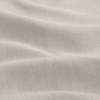 Close-up of a light beige fabric with a slightly textured surface and gentle, soft folds creating subtle shadows.