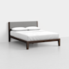 A modern wooden bed frame with a padded gray headboard, neatly made with white bedding and two white pillows, set against a plain white wall and light gray floor.