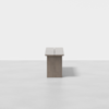 A minimalist wooden bench with a rectangular shape and clean lines, photographed from the side against a plain white background.