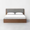 A modern wooden bed frame with a gray upholstered headboard, dressed with white sheets, two neatly placed pillows, and positioned against a plain white wall on a gray floor.
