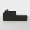 A modern dark gray sectional sofa with a chaise lounge, viewed from the side against a plain white background. The design is minimalistic with tufted back cushions and clean lines.