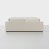 A minimalist, light beige, modular sofa viewed from the back, set against a plain white background. The design features clean lines and plush cushions, creating a modern and inviting appearance.