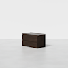 A dark wood two-drawer dresser sits on a plain white floor with a white background. The design is modern and minimalistic.