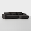 A modern dark gray sectional sofa with three seat cushions, matching back cushions, and an attached chaise lounge on the right side, set against a plain white background.