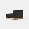 A modern, armless black upholstered chair with a low backrest and light wooden base, set on a smooth, light-colored floor against a plain white background.
