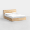 A minimalist wooden bed frame with a rectangular headboard and base, made from light-colored wood, is shown against a plain white background. The bed is neatly made with white sheets and two pillows.