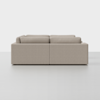 A modern, light beige sectional sofa viewed from the back, set against a plain white background. The sofa has clean lines, boxy cushions, and a minimalist design.