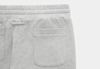 Close-up of the upper back portion of light gray sweatpants featuring an elastic waistband and a single patch pocket on the right side. The fabric appears soft and comfortable.