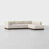 A modern, L-shaped sectional sofa with light beige upholstery and a dark brown base, set against a plain white background.