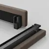 Two upholstered bed frame sections are aligned on a light gray surface, showing a close-up of exposed black metal brackets designed for assembly and connection.